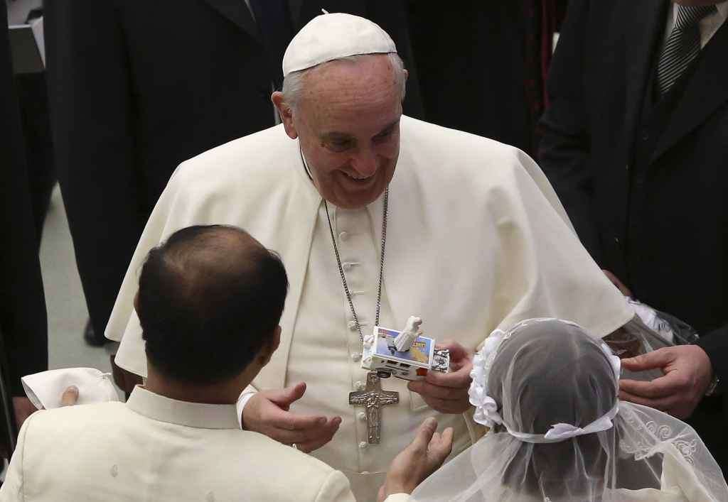 Pope Francis receives a toy of himself as he leads his Wednesday general audience in Paul VI hall at the Vatican